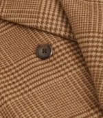Detail of the tan plaid fabric and button on the My Secret Santa long wool overcoat, a film inspired coat.