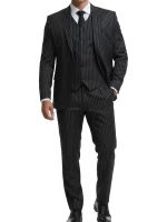 A man wearing a tailored black suit with fine white pinstripes, featuring a modern fit and notched lapels.