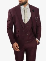 A man wearing a Mens Peak Lapel 3 Piece Burgundy Suit with a slim-fit jacket, matching waistcoat, and trousers.