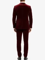 A man wearing a sharp Mens 2 Piece Maroon Velvet Tuxedo with black satin-style lapels and a slim-fit design.