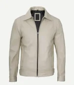 Front view of a minimalist beige leather jacket, partially zipped, showing a black lining, side slit pockets, a straight hem, and button-cuffed sleeves.