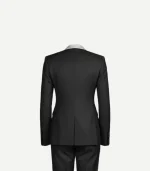 The back view of a black double-breasted tuxedo jacket and trousers. The jacket shows a structured, tailored silhouette with a single center vent at the hem and a glimpse of the silver shawl collar at the neck.