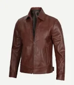 A brown leather jacket shown at an angle, emphasizing the natural grain of the leather and the structured fit of the sleeves.