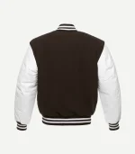 The rear view of the varsity jacket, showing a solid dark brown wool back panel and full-length white leather sleeves. The ribbed collar and waistband continue the brown and white striped pattern, maintaining a clean and sporty aesthetic.