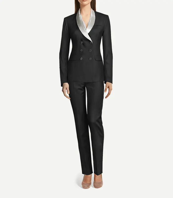 Womens Black Double Breasted Shiny Tuxedo A full-length front view of a woman wearing a black, double-breasted tuxedo suit. The blazer features a slim fit, four black buttons, and a contrasting silver satin shawl lapel. The look is completed with matching black slim-fit trousers and pointed-toe heels.