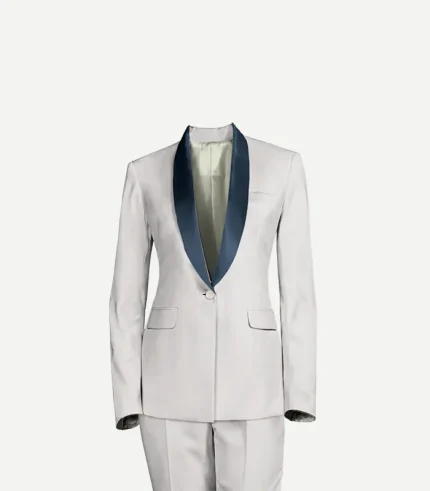 A studio shot of a white women’s tuxedo jacket and matching trousers against a plain white background. The jacket features a single-button closure and a contrasting navy blue satin shawl lapel. It has two flapped hip pockets and a slim, tailored fit.