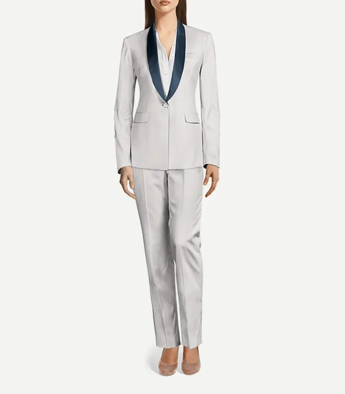 Womens White Tuxedo With Shawl Lapels A full-length view of a woman wearing a tailored white tuxedo suit. The outfit consists of a single-button blazer with deep navy blue shawl lapels and matching slim-fit trousers with a sharp center crease. She is wearing a white button-down shirt underneath and neutral-toned pointed-toe heels.