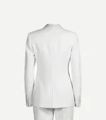 The back view of a women’s white velvet tuxedo jacket. The image shows a tailored, form-fitting silhouette with a center seam, subtle shoulder padding, and four small buttons on each sleeve cuff. The high-quality velvet fabric has a soft, matte sheen.