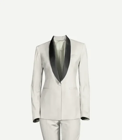 A close-up studio shot of a women’s white wool tuxedo jacket featuring prominent black satin shawl lapels. The jacket has a structured, fitted waist, a single button, and subtle welt pockets, shown against a plain light background.