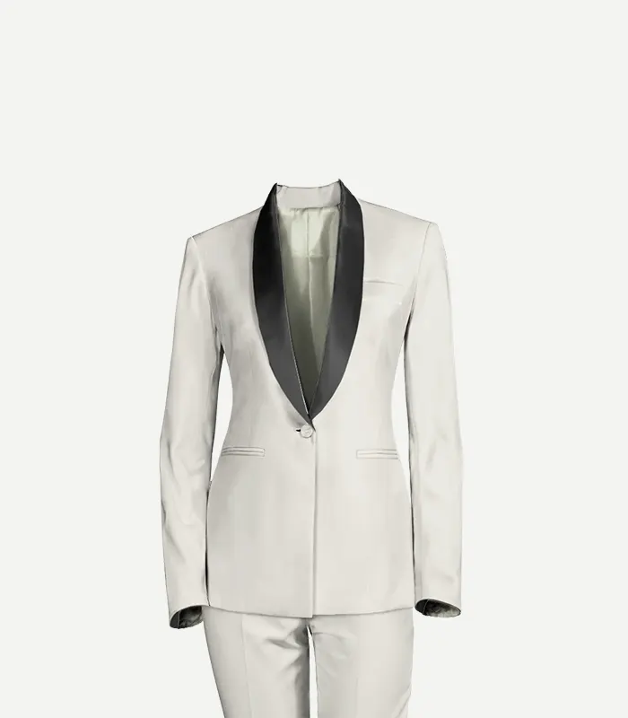 A close-up studio shot of a women’s white wool tuxedo jacket featuring prominent black satin shawl lapels. The jacket has a structured, fitted waist, a single button, and subtle welt pockets, shown against a plain light background.