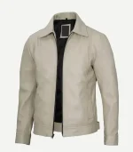 Three-quarter view of an open beige leather jacket with a black interior lining, silver zipper detail, side pockets, and a structured, classic collar design.