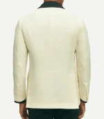 A rear view of the classic-fit off-white dinner jacket, showing the black contrast collar extending around the neck. The jacket features a clean, no-vent (solid) back design for a traditional formal silhouette, with four buttons on each sleeve cuff and black trim visible at the wrists.