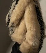 A profile view of the coat, emphasizing the thick padding and shaggy texture of the fur. The vertical black stripe is visible on the arm and shoulder area.