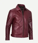 women's maroon leather jacket displayed at an angle, featuring vertical pocket stitching and a sleek, tailored fit through the sleeves.