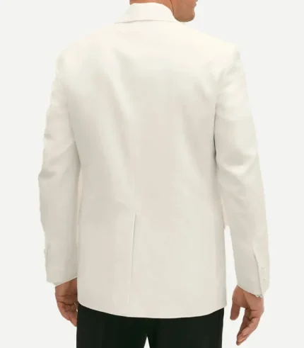 A rear view of a man wearing a white wool dinner jacket with a single center vent. The jacket has a regular fit through the torso and sleeves, with four buttons visible on the cuffs, paired with black formal trousers.