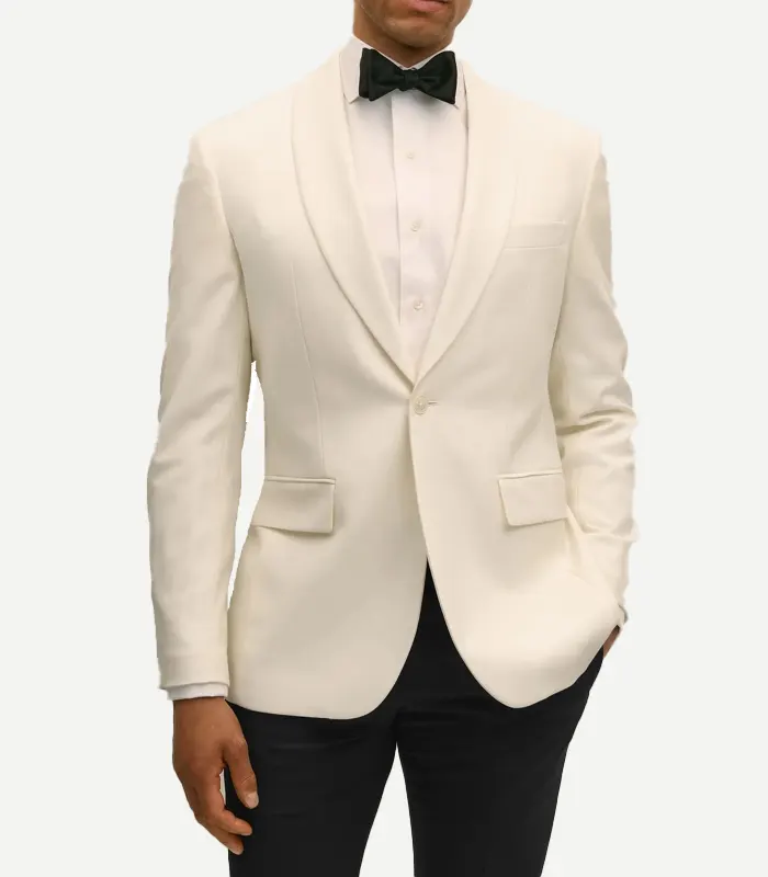 slim-fit-wool-white-dinner-jacket Front view of a man wearing a slim-fit white wool dinner jacket. This version features a more contoured waist and narrower shawl lapels compared to the regular fit. It includes a single-button closure, flap pockets, and is paired with a white shirt and black bowtie.