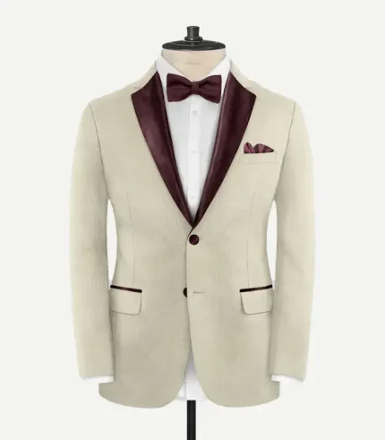 Front view of the Stretch Beige Wool Tuxedo Jacket featuring burgundy satin peak lapels, a single-button closure, and matching burgundy trim on the pocket flaps.