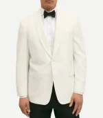A front-facing view of a man wearing a white wool dinner jacket with a shawl lapel and a single-button closure. The jacket is paired with a white dress shirt, a black bowtie, and black trousers. The jacket features two flap pockets and a welt pocket on the chest.