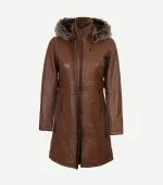 Front view of a women's mid-length brown leather coat featuring a zip-up front, vertical panel stitching, and a hood with plush fur trim.
