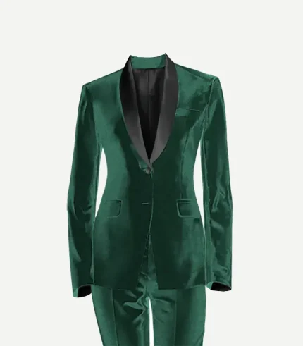 A studio product shot of a women’s emerald green velvet tuxedo jacket and matching trousers against a plain white background. The jacket features a slim fit, a single-button closure, and a contrasting black satin shawl lapel.