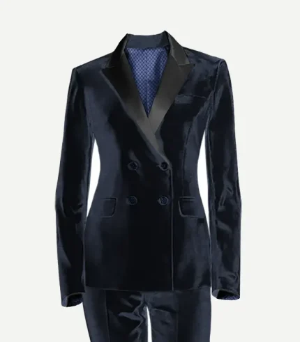 A studio product photograph of a women's navy blue velvet double-breasted tuxedo jacket. The jacket features sharp black satin peak lapels, four decorative front buttons, and a visible blue patterned lining at the neck. It is shown with matching navy velvet trousers against a clean white background.