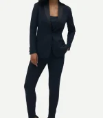 Full-length front view of a woman navy tuxedo featuring black contrast shawl lapels, a single-button closure, and a dark camisole underneath.