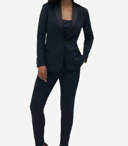 Full-length front view of a woman navy tuxedo featuring black contrast shawl lapels, a single-button closure, and a dark camisole underneath.