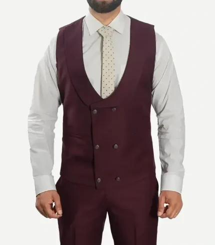 A close-up macro shot of the chest on the burgundy three-piece suit, detailing the wide peak lapel with buttonhole stitching, the double-breasted vest closure, and a black bowtie.