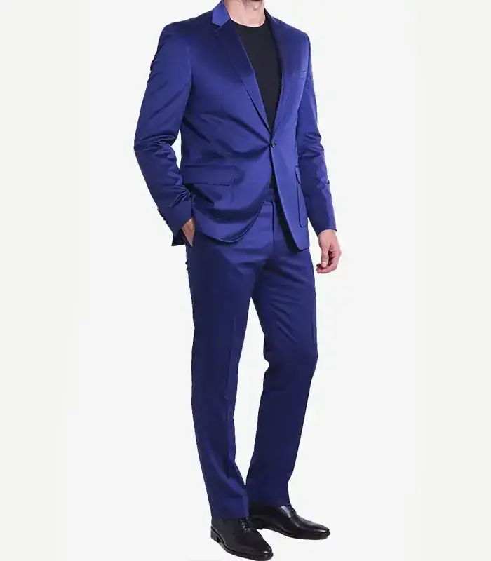 Side angle view of a model posing in a premium royal blue velvet suit jacket and trousers, styled casually with a black t-shirt.